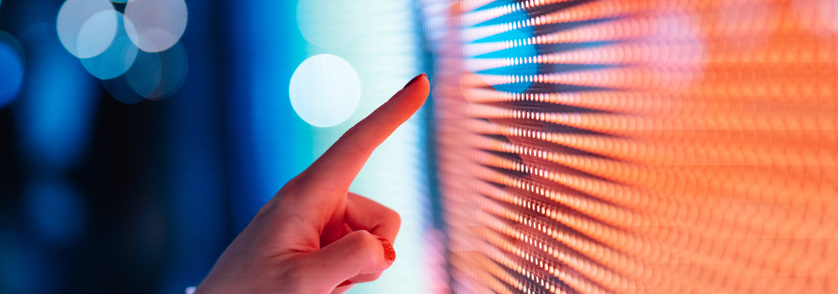 Close Up Of Female Hand Touching Illuminated Digital Display In The Dark.