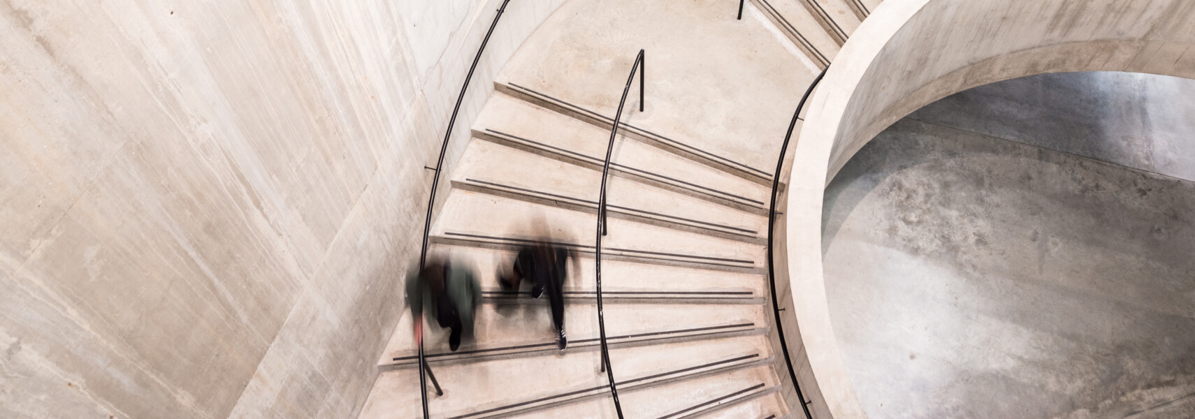 Blurred Motion Of People On Spiral Staircase
